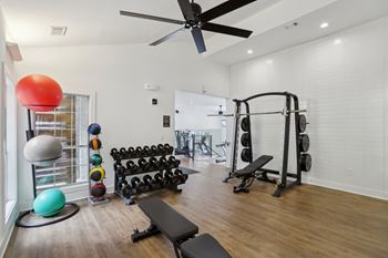 A gym with a variety of equipment including weights and exercise balls.